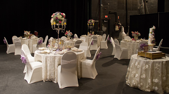 White wedding tables with purple flowers on chairs