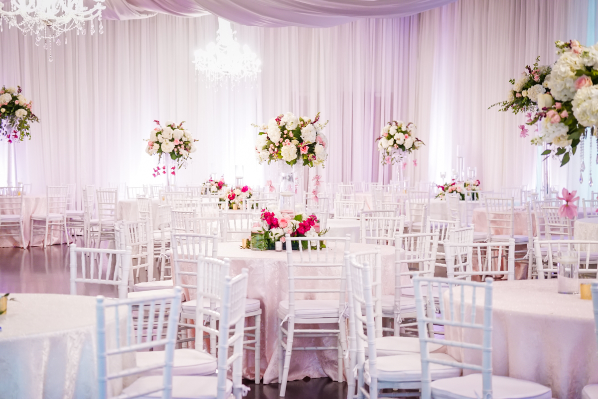 Reception Hall set up for wedding reception, all white with pops of pink.