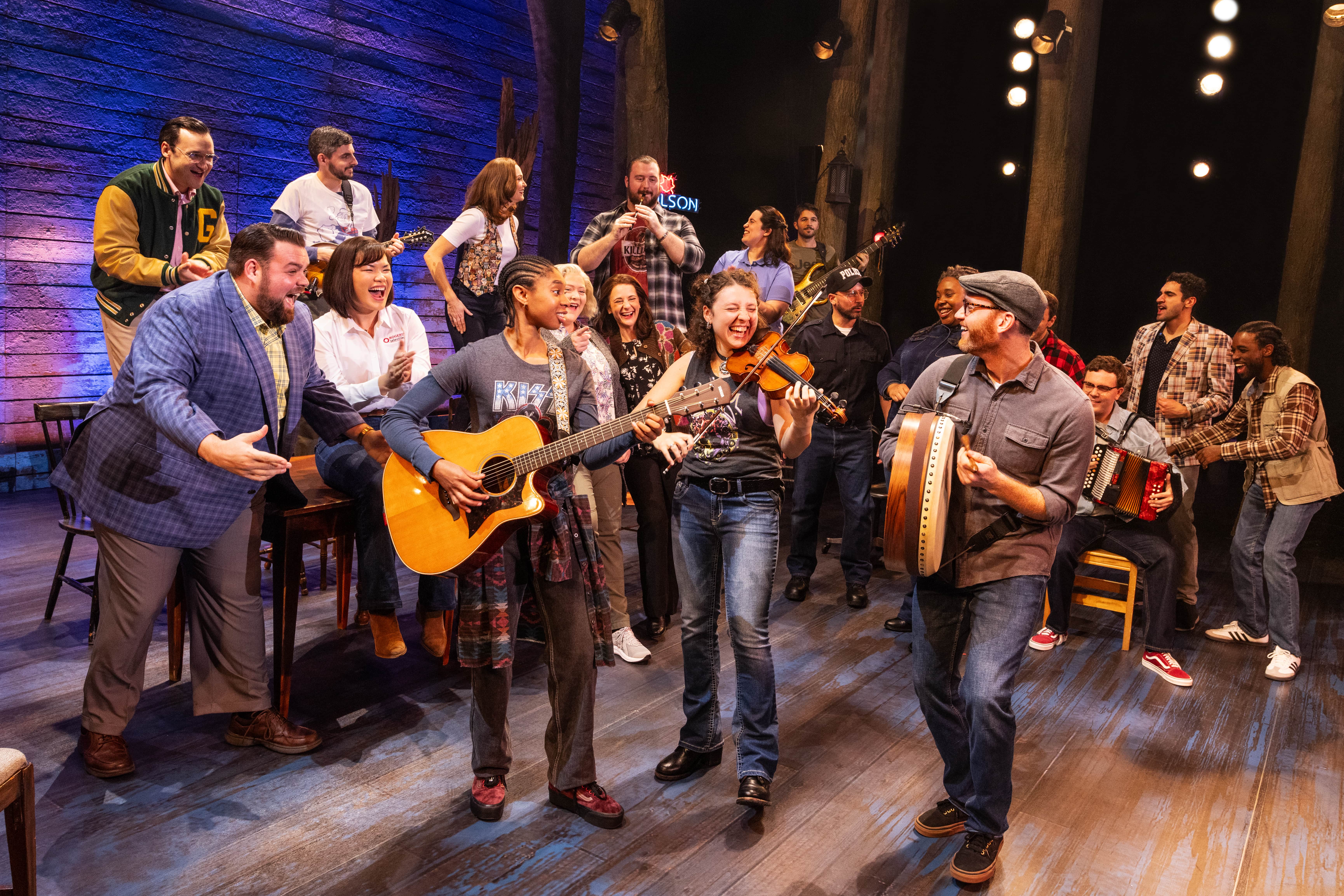 Touring Cast of Come From Away 2023 playing live instruments on stage